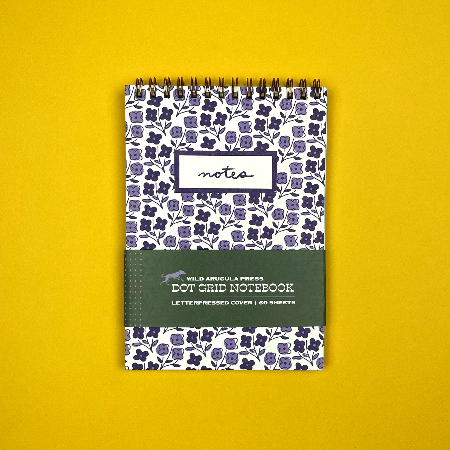 Notebook with floral pattern and 'notes' label on a yellow background