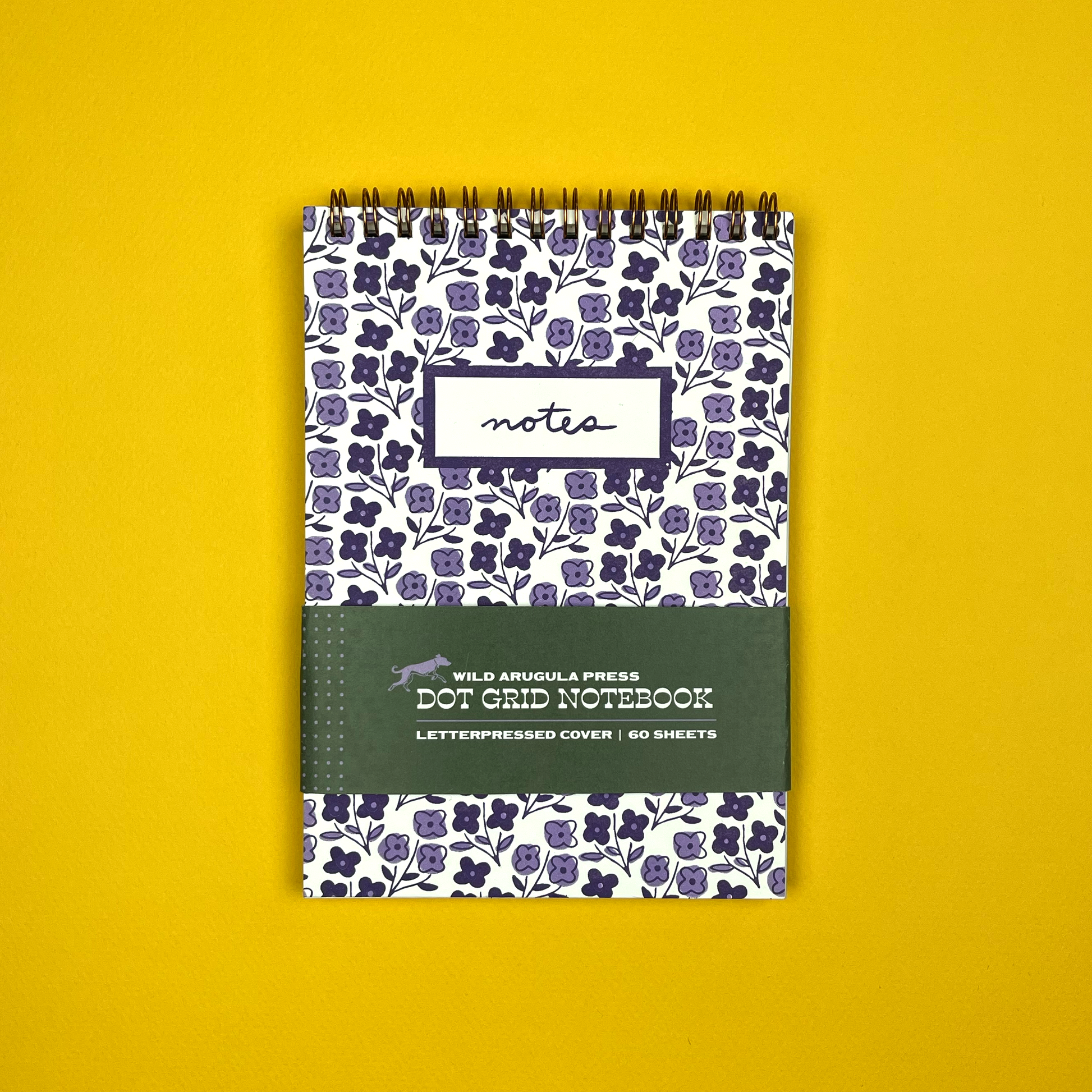 Notebook with floral pattern and 'notes' label on a yellow background